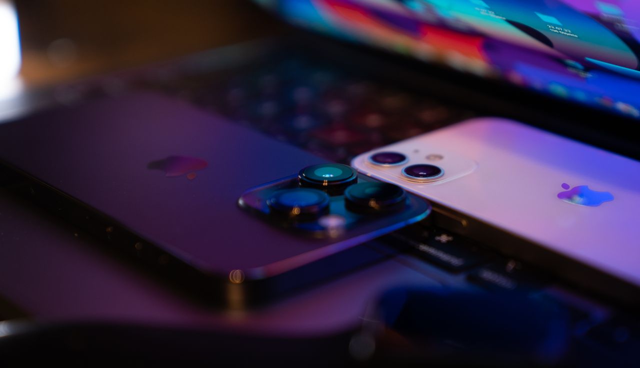 Home Close-up image of two modern smartphones placed on a laptop keyboard, highlighting technology design.