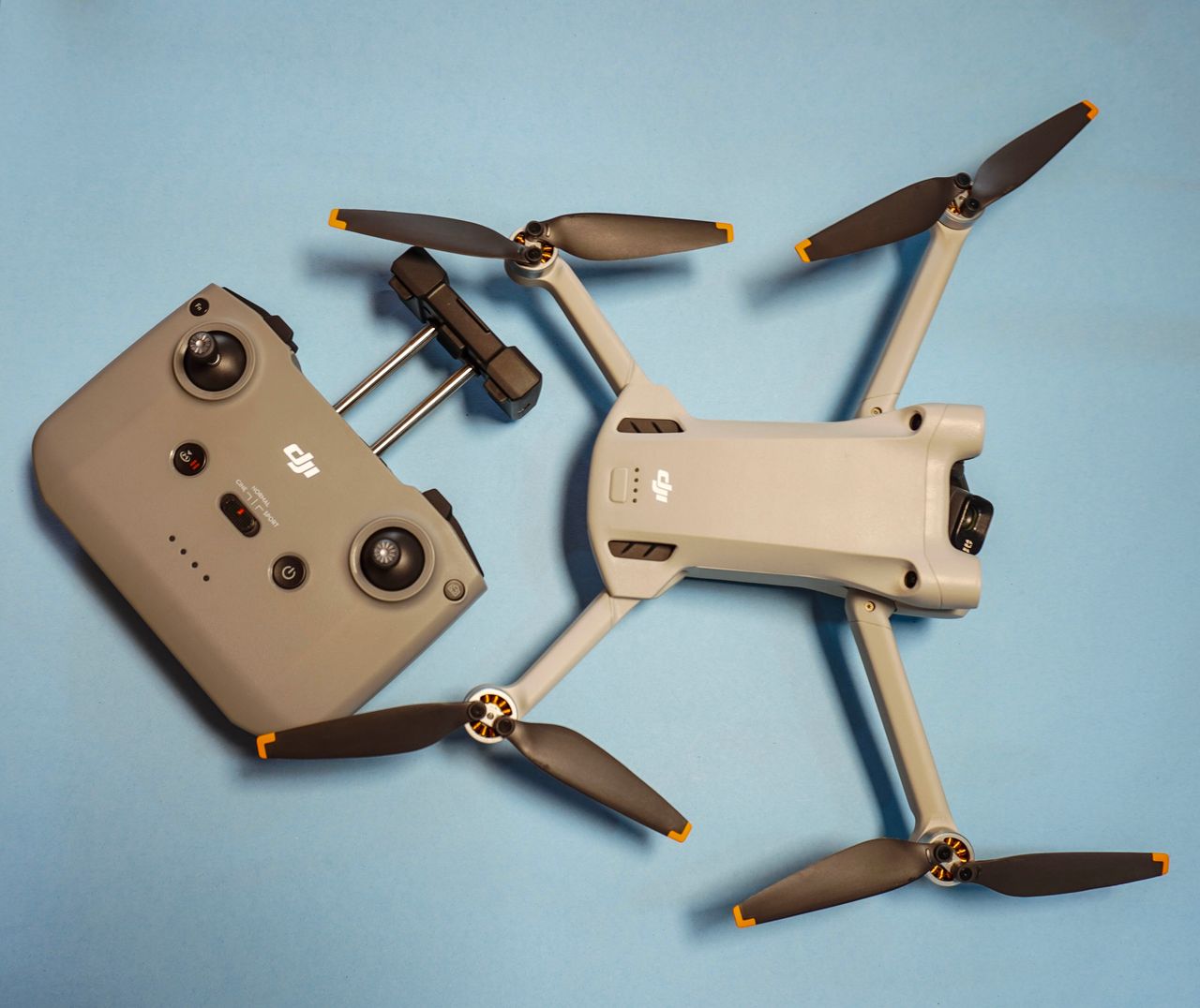Home Top-down view of a drone and its controller on a blue surface.