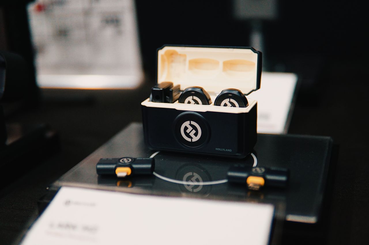Services Close-up of wireless earbuds in an open charging case on a display table.