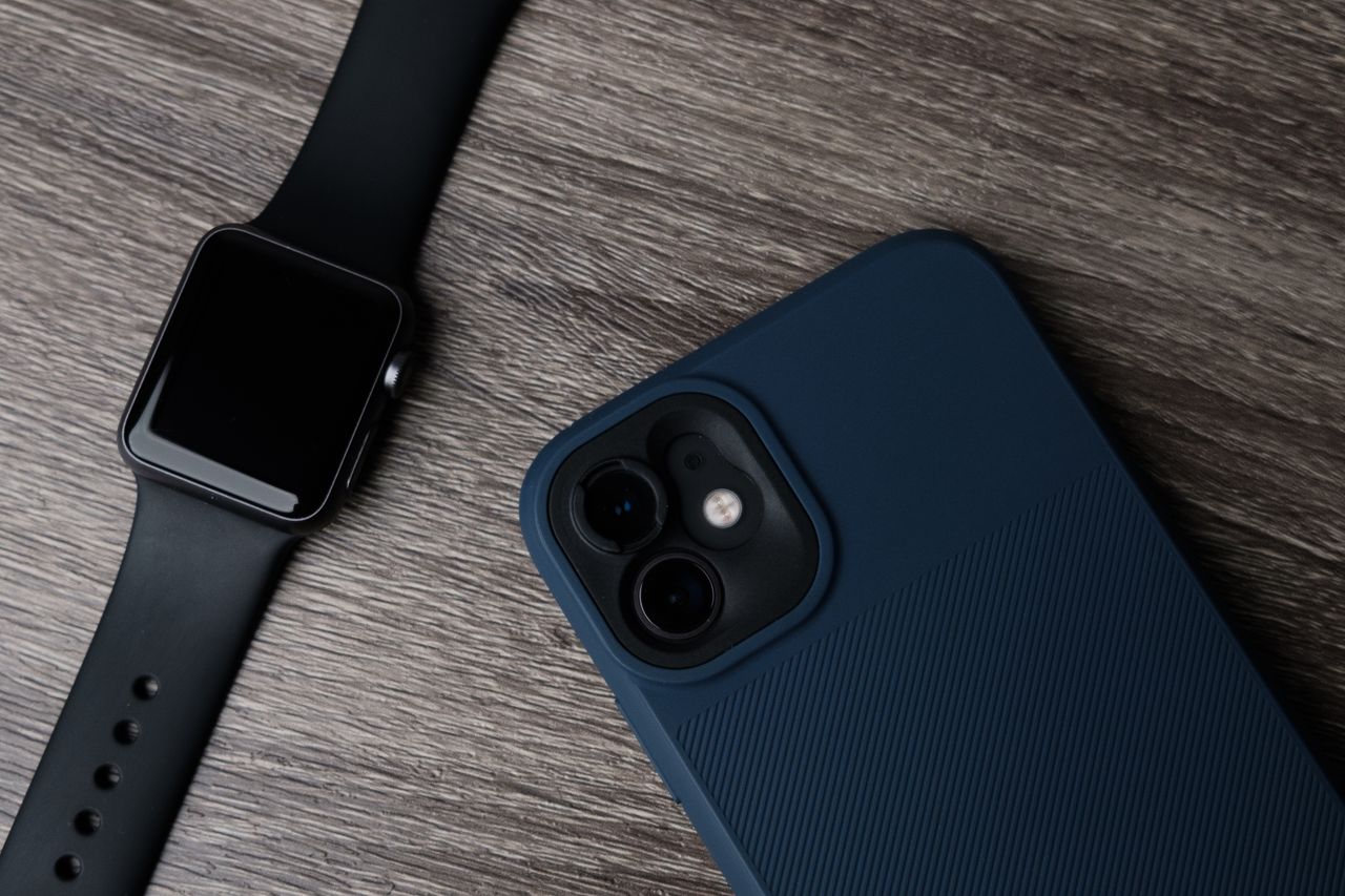 Home Close-up of a smartwatch and smartphone on a wooden surface, showcasing modern technology.
